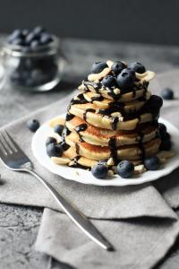 a plate with a stack of pancakes and blueberries at The Retreat at Froog Moore Park in Tamworth