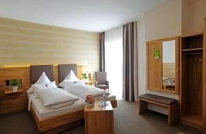 Gasthof Hotel Zum Hirsch***S في Kirchen: غرفة الفندق بسرير وطاولة