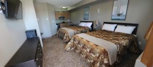 a hotel room with two beds and a television at Alberta Beach Inn and Suites in Albert Beach (Alberta)