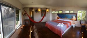 um quarto com uma cama e uma grande janela em Casa Ofelia em Mazunte