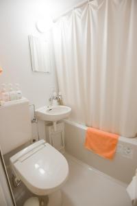 Ryogoku River Hotel في طوكيو: حمام ابيض مع مرحاض ومغسلة