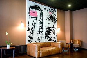 a couch in a room with a painting on the wall at New Hotel Charlemagne in Brussels