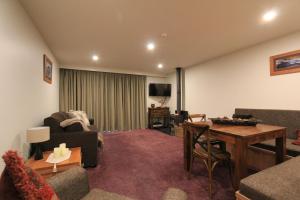 a living room with a couch and a table at Thredbo 31 in Thredbo