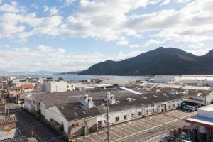 vistas a una ciudad con montañas y un cuerpo de agua en Global Resort ONO de LUNE, en Hatsukaichi