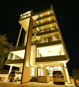 a building with two cars parked in front of it at K Hotels Entebbe in Entebbe