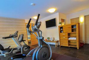 Gasthof Hotel Zum Hirsch***S في Kirchen: صالة ألعاب رياضية مع دراجتين تمرين في غرفة