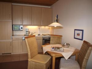 a kitchen with a table and chairs in a kitchen at Haus Reimann in Altenau