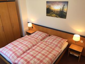 a bed in a hotel room with two night stands at Haus Reimann in Altenau