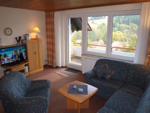 a living room with a couch and a table and a tv at Haus Reimann in Altenau