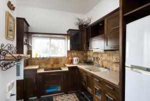 a kitchen with wooden cabinets and a sink at Eshkol Housing Carmel Center: Forest retreat in Haifa