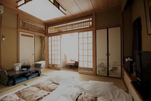a bedroom with a large bed in a room with windows at Ryogoku River Hotel in Tokyo