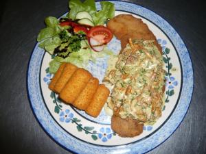 ein Teller mit Fisch und Gemüse auf dem Tisch in der Unterkunft Pension Zum Fuchsbau in Schmorkau