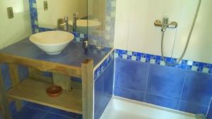 y baño de azulejos azules con lavabo y ducha. en Cabaña Cajón del Maipo en San José de Maipo
