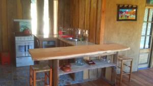 uma cozinha com uma mesa de madeira num quarto em Cabaña Cajón del Maipo em San José de Maipo