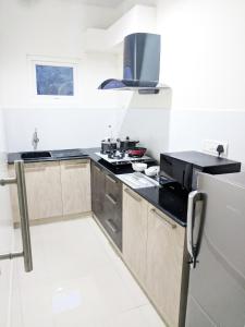 a kitchen with a stove and a refrigerator at Clyford Suites in Bangalore