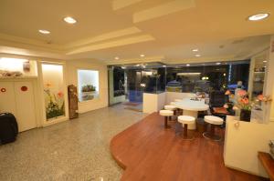 a lobby with a table and stools in a building at Maria Hotel in Zhongzheng