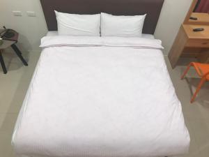 a bed with white sheets and pillows in a room at Jin in Dongshan