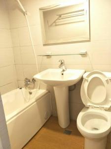 La salle de bains est pourvue de toilettes, d'un lavabo et d'une baignoire. dans l'établissement Maria Hotel, à Zhongzheng