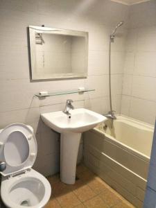 a bathroom with a toilet and a sink and a tub at Maria Hotel in Zhongzheng