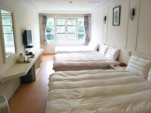 una camera d'albergo con 2 letti e una scrivania di Maria Hotel a Zhongzheng