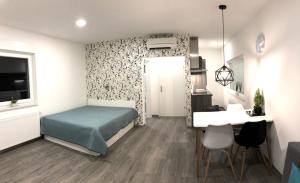 a bedroom with a bed and a desk and a table at Luxury Studio Apartments in Ljubljana