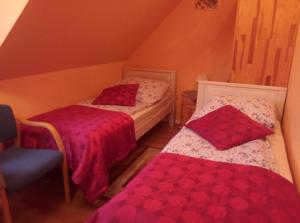 a small room with two beds and a chair at Willa na Skarpie in Kluszkowce