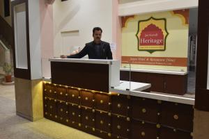 un hombre de pie en un podio detrás de un mostrador en Jaipur Hotel New - Heritage Hotel, en Jaipur