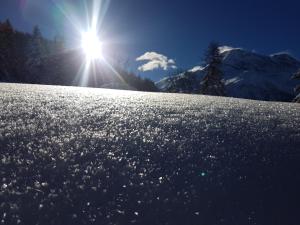 a snow covered slope with the sun in the background at Arpege Des Neiges in Sainte-Foy-Tarentaise