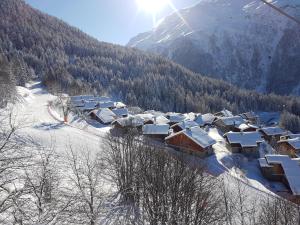 a village covered in snow in front of a mountain at Arpege Des Neiges in Sainte-Foy-Tarentaise