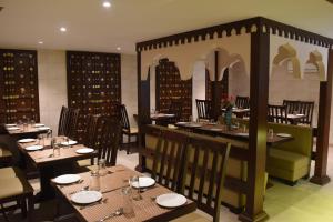 a restaurant with tables and chairs in a room at Jaipur Hotel New - Heritage Hotel in Jaipur