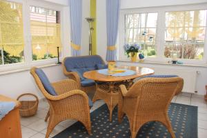 a living room with a table and chairs and windows at Appartementpark Seeblick in Plau am See