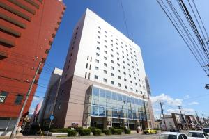 a tall white building on the side of a street at Hotel Hokke Club Hakodate in Hakodate