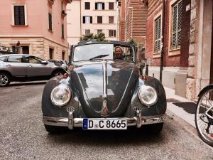 a man sitting in an old car on a street at San Pietro Leisure and Luxury in Rome