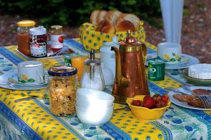 una mesa con mantel amarillo y azul con productos para el desayuno en Le Collet Vert en Wamin