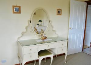 a white dresser with a mirror on top of it at Annie's Balquhidder Cottage in Victor Harbor