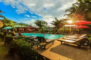 a pool with a bunch of chairs and umbrellas at Lanta Klong Nin Beach Resort in Ko Lanta