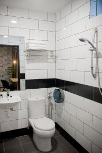a white bathroom with a toilet and a sink at Big Banana Hotel, Sg Petani in Sungai Petani