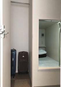 a door to a room with a bed and a suitcase at 1 Night 1980 Hostel Tokyo Asakusa Simple Stay in Tokyo
