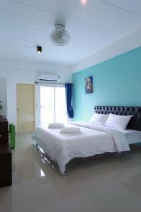 ein Schlafzimmer mit einem großen Bett mit blauer Wand in der Unterkunft 2Bedtel in Bangkok