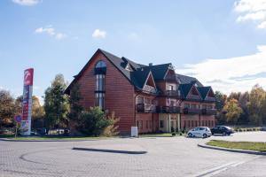 een groot huis met een auto ervoor geparkeerd bij Hotel Hetmański in Rawa Mazowiecka