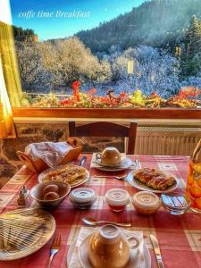 einen Tisch mit Teller mit Lebensmitteln und einem Fenster in der Unterkunft Guest House Pantos Kairou in Karkaloú
