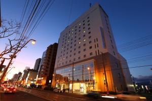 a tall building on a city street at night at Hotel Hokke Club Hakodate in Hakodate