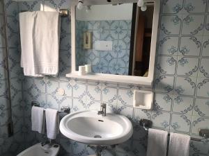 a bathroom with a sink and a mirror and towels at Al Bersagliere in Noale