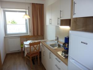 a kitchen with a sink and a table with a chair at Appartement Windisch in Tirolo +8 photos
