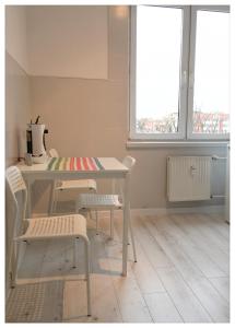 a kitchen with a table and chairs and a window at Apartament Mikołajek Stare Miasto in Toruń