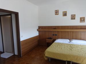 um quarto com uma cama com uma cabeceira de madeira em Al Bersagliere em Noale