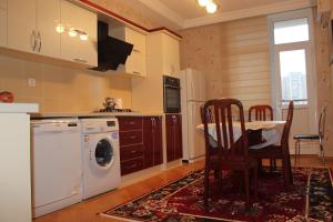 a kitchen with a washing machine and a table and chairs at Apartment at Jafar Khandan 200 in Baku +12 photos