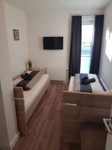 ハイリゲンハーフェンにあるStrandGut inkl Wäsche Setのベッドルーム1室(ベッド2台、壁掛けテレビ付)