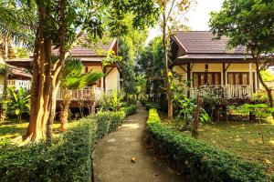 un chemin menant à une maison dans un jardin dans l'établissement Lanta Klong Nin Beach Resort, à Ko Lanta