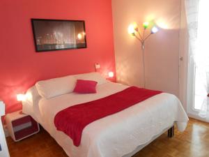 ein Schlafzimmer mit einem Bett mit einer roten Wand in der Unterkunft Gîte Bretagne in Rouen
